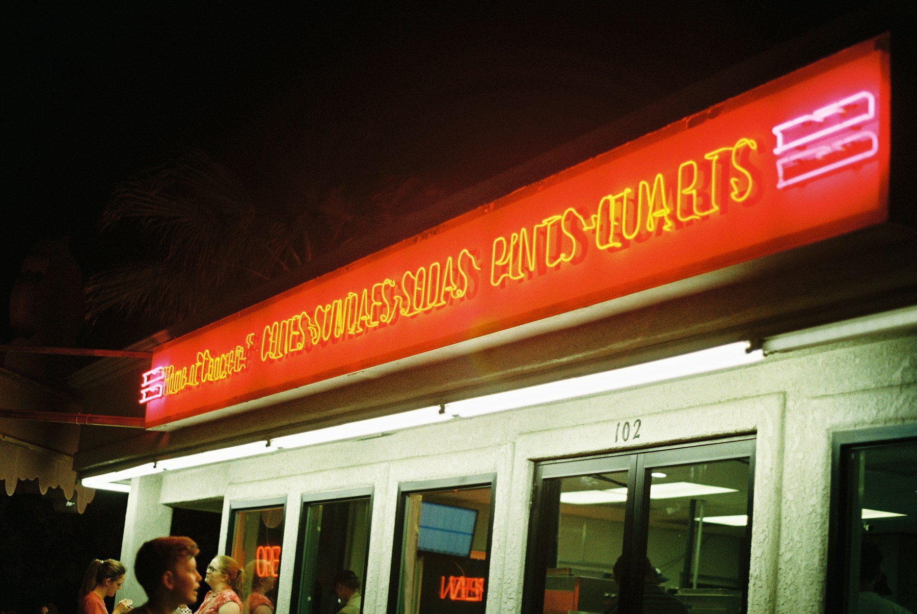 Letreiro iluminado em fachada comercial — imagem ilustrativa